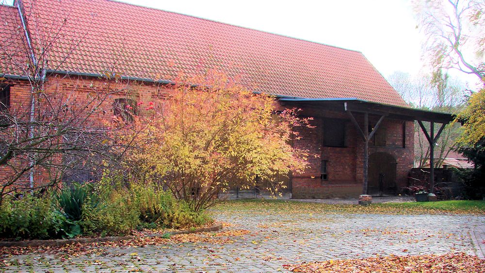 Denkmalschutz-Bauerrnhof-
Scheune-mit-Vordach-ehemalige Klaergrube-bepflanzt